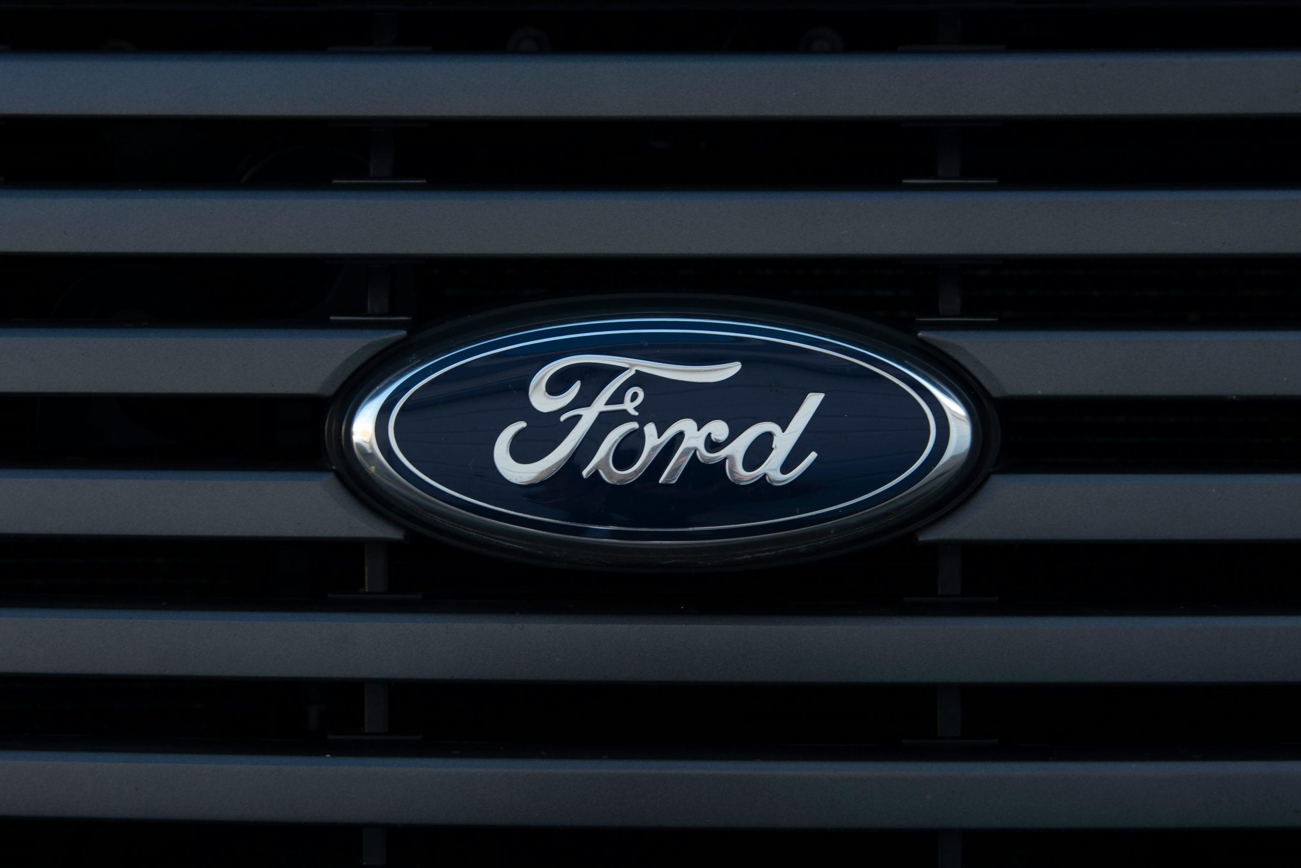 Detailed view of a Ford emblem mounted on a vehicle grille, showcasing modern design.